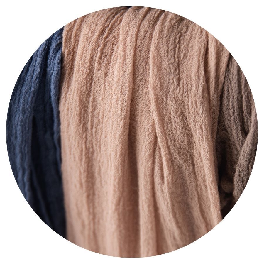 Close-up of soft navy blue and blush pink wool yarn fibers arranged in parallel strands.