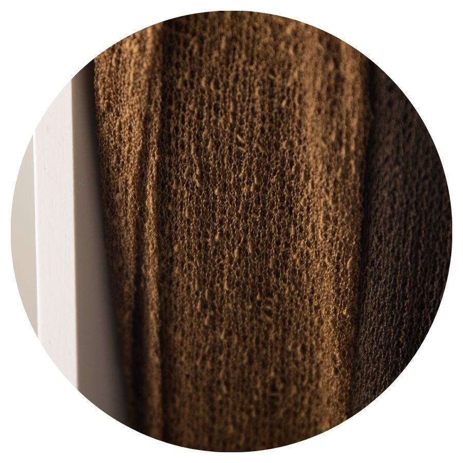 Close-up of dark brown textured knit fabric with vertical ribbed pattern detail.