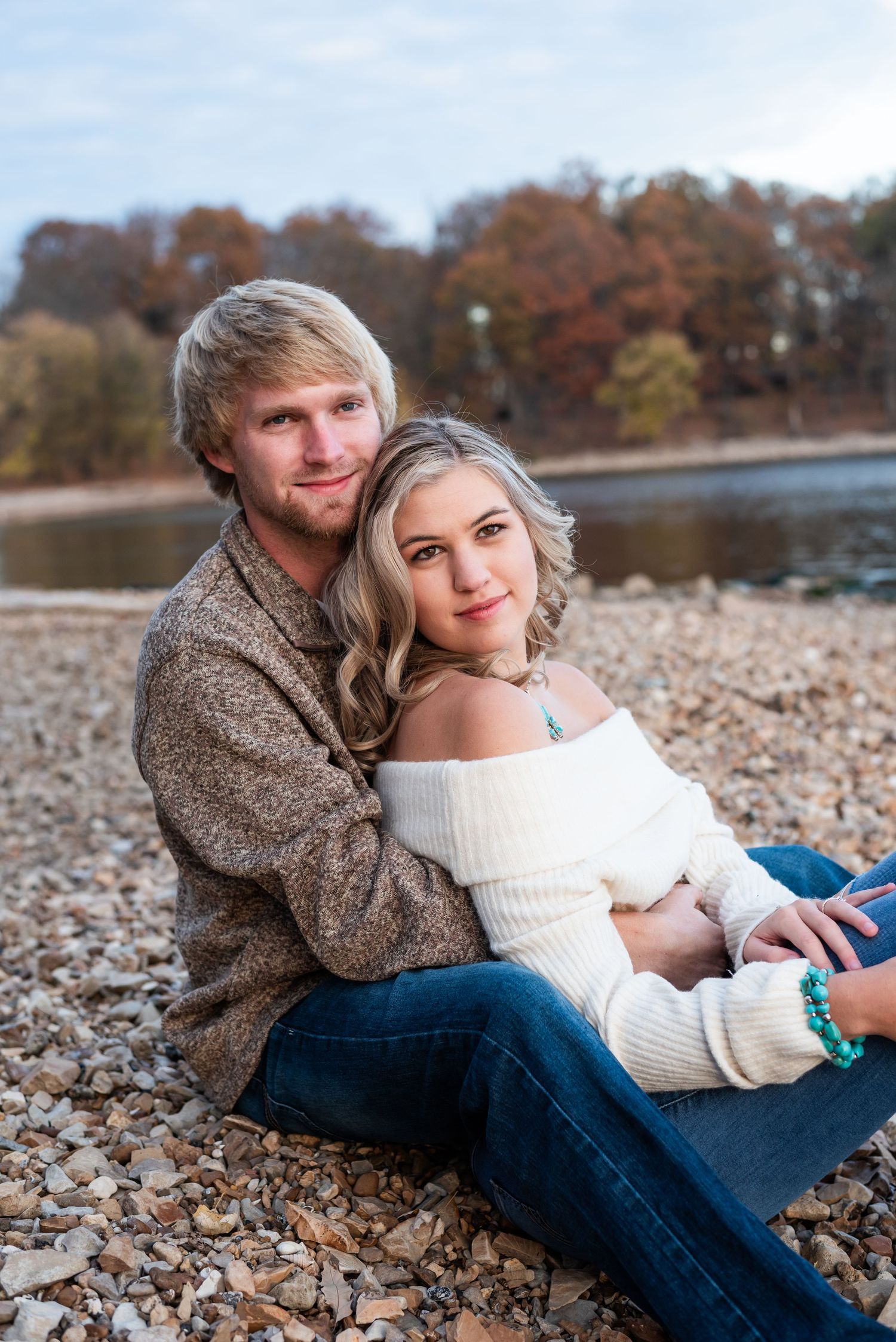 A couple sitting by the lake looking off into the distance for their engagement portraits in Kuttawa, Kentucky.
