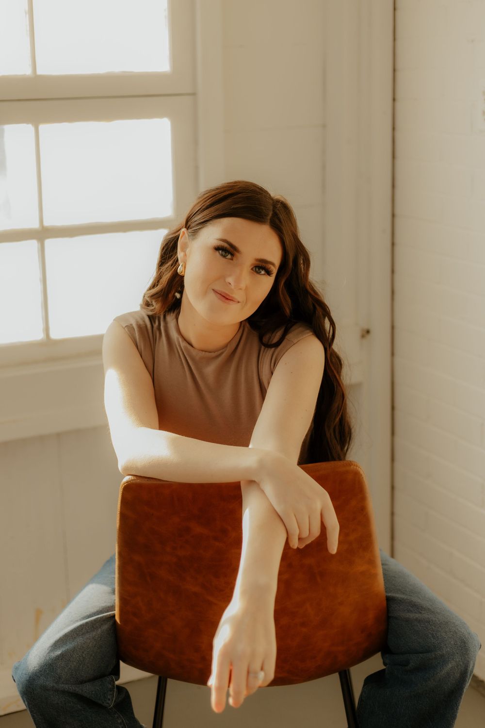 Relaxed indoor portrait session on leather chair with natural window light Western
