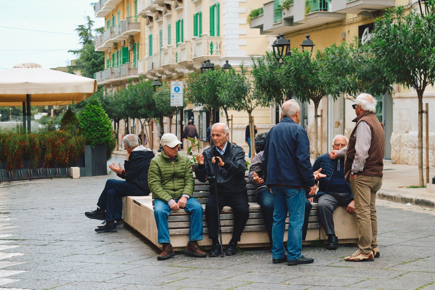 A group gathering on a bench in a traditional Italian town square.