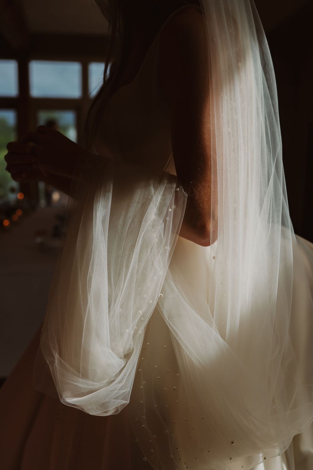 Ethereal white wedding veil flows gracefully in soft natural light creating a dreamy atmosphere.