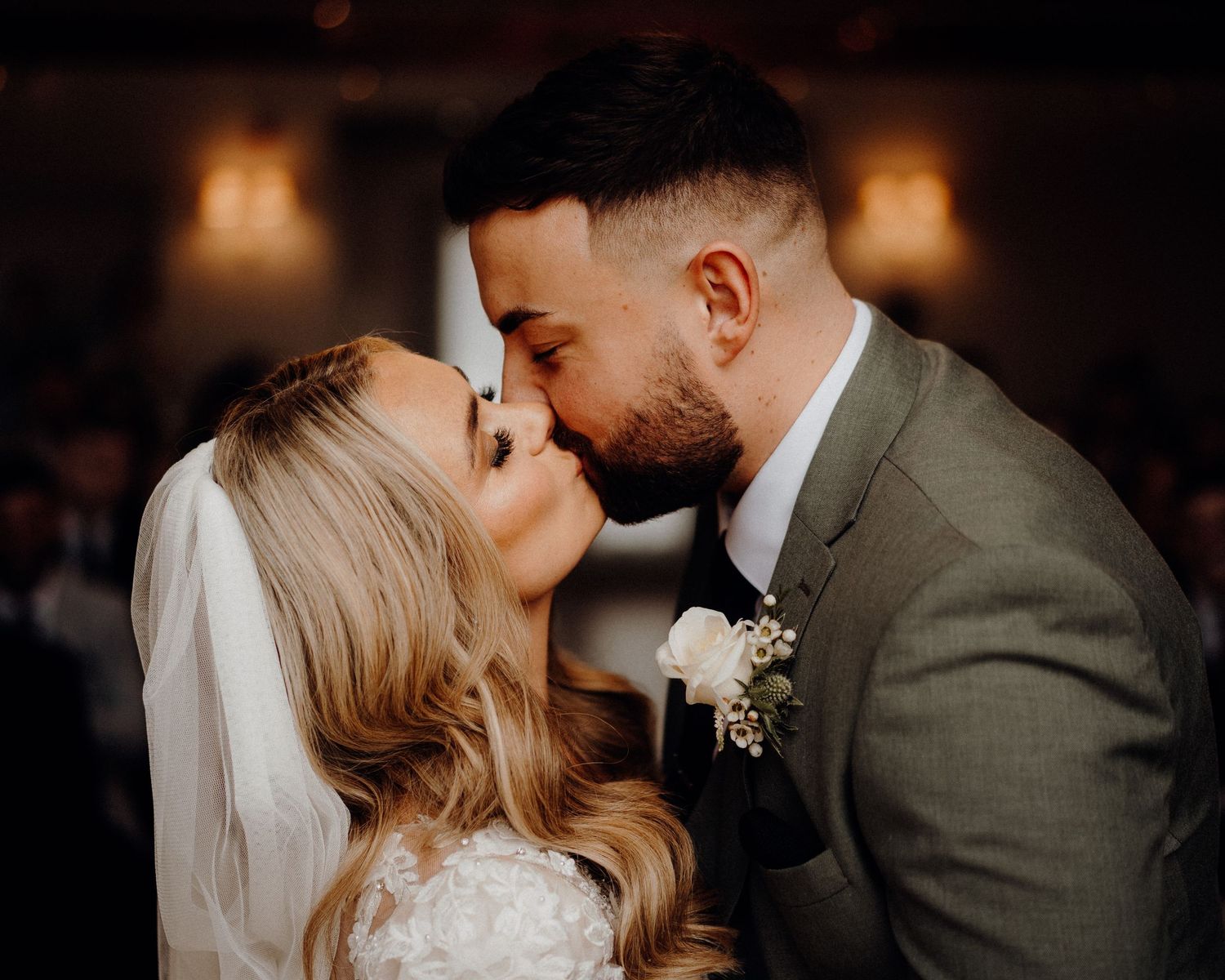 Intimate wedding moment captured in warm indoor lighting.