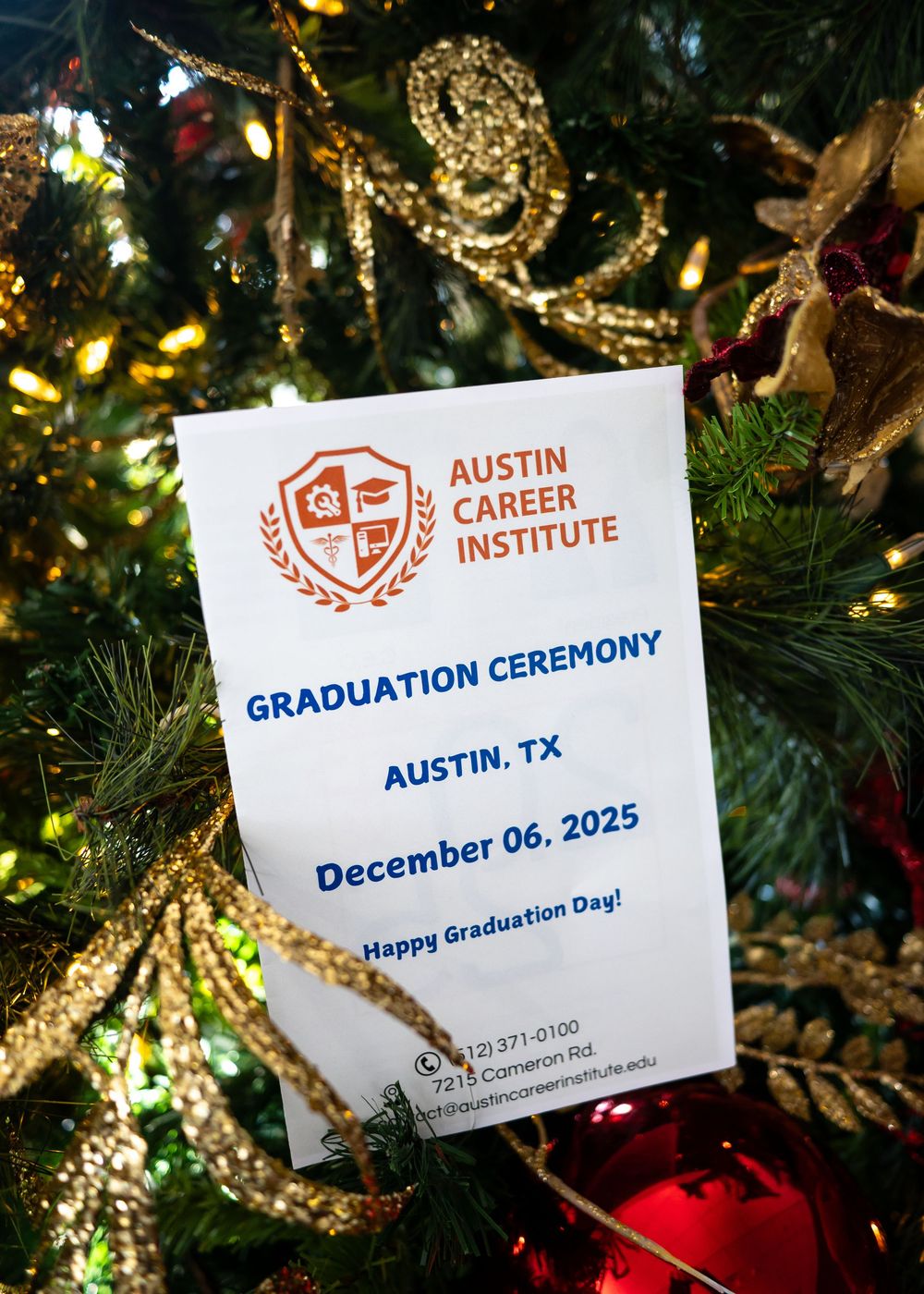 Austin Career Institute graduation ceremony program card displayed on a decorated Christmas tree.