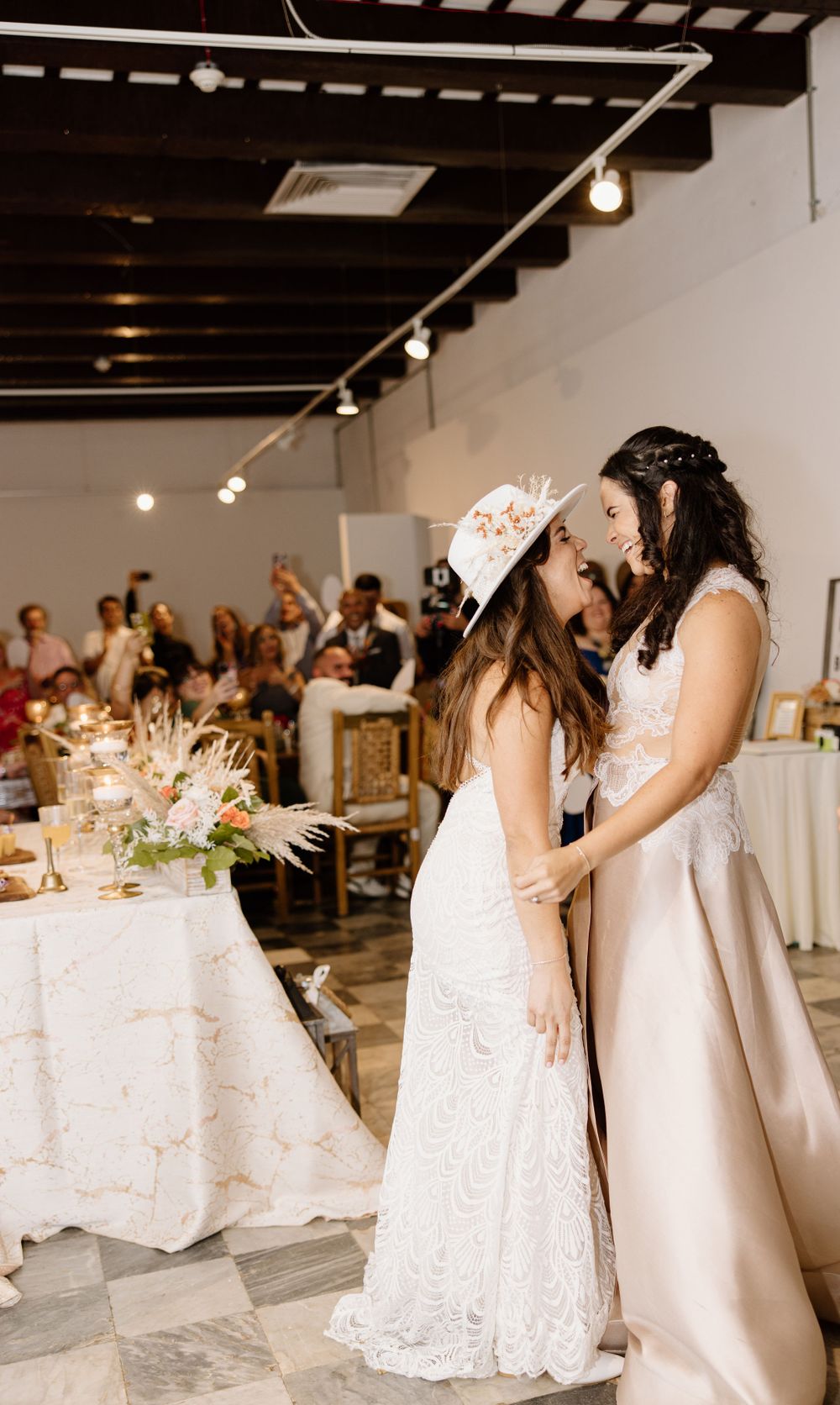 Two brides sharing an intimate moment during their wedding reception.