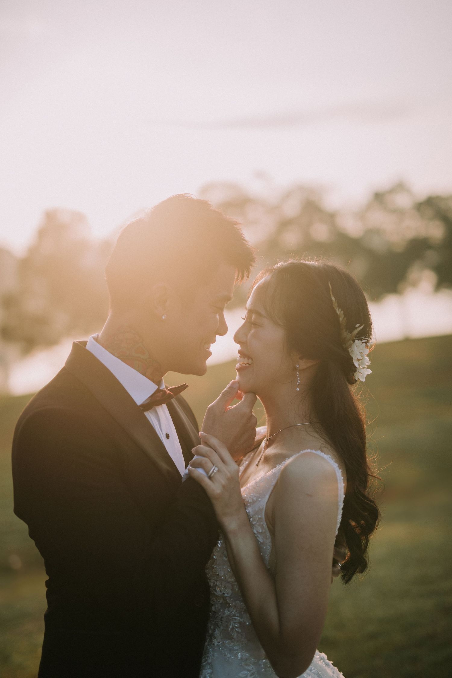 A romantic sunset moment between newlyweds in formal attire.