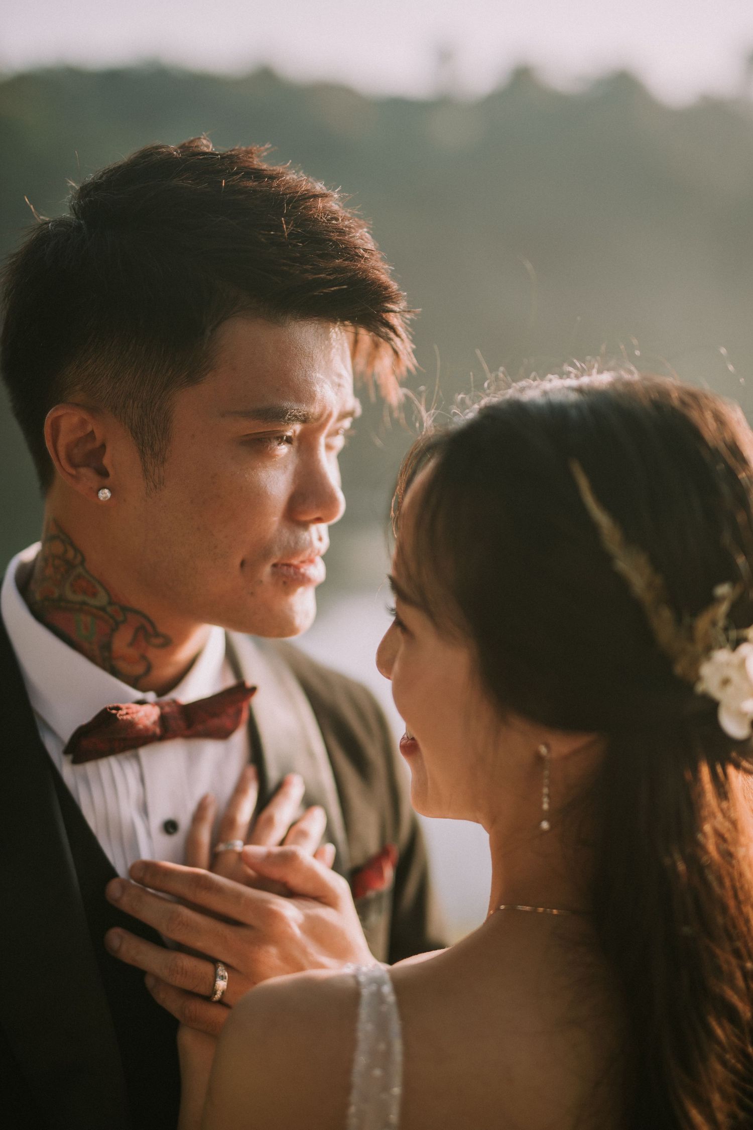 Romantic couple shares an intimate moment in formal attire against soft natural lighting.