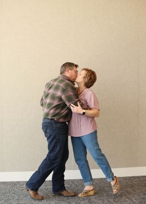 Couple in casual wear dancing and embracing in a playful sequence.