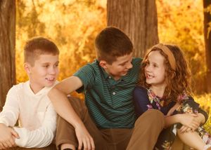 Casual group interaction captured during outdoor family photo session at sunset.