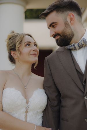 A romantic wedding photoshoot showing tender moments between newlyweds in formal attire against a light background.