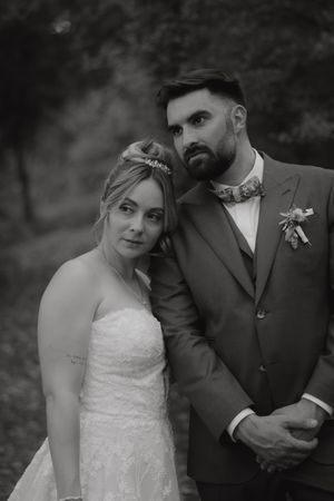 Black and white wedding portraits showing elegant couple in formal attire in romantic outdoor setting.