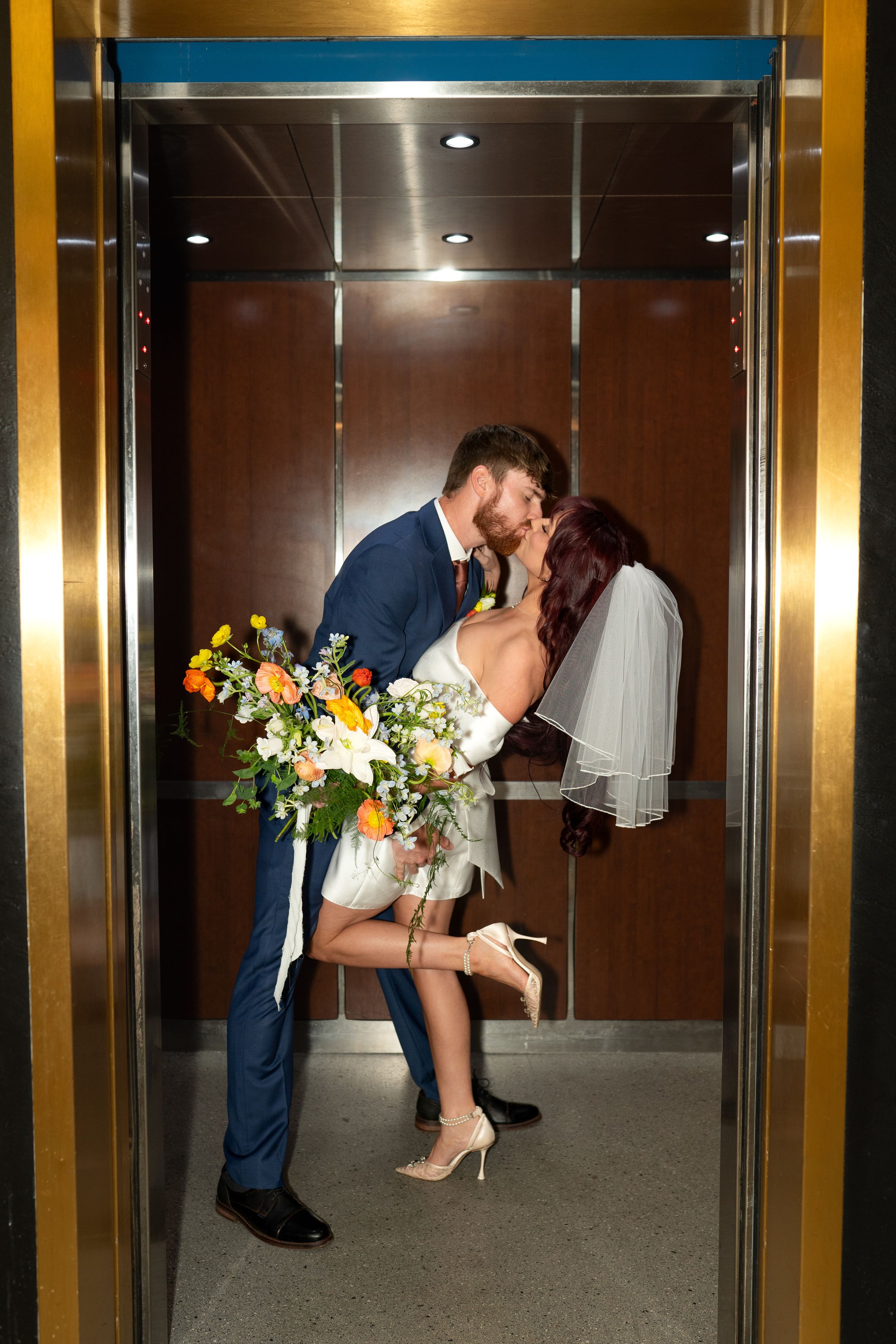 Romantic elevator photo sequence of newlyweds with colorful bouquet.