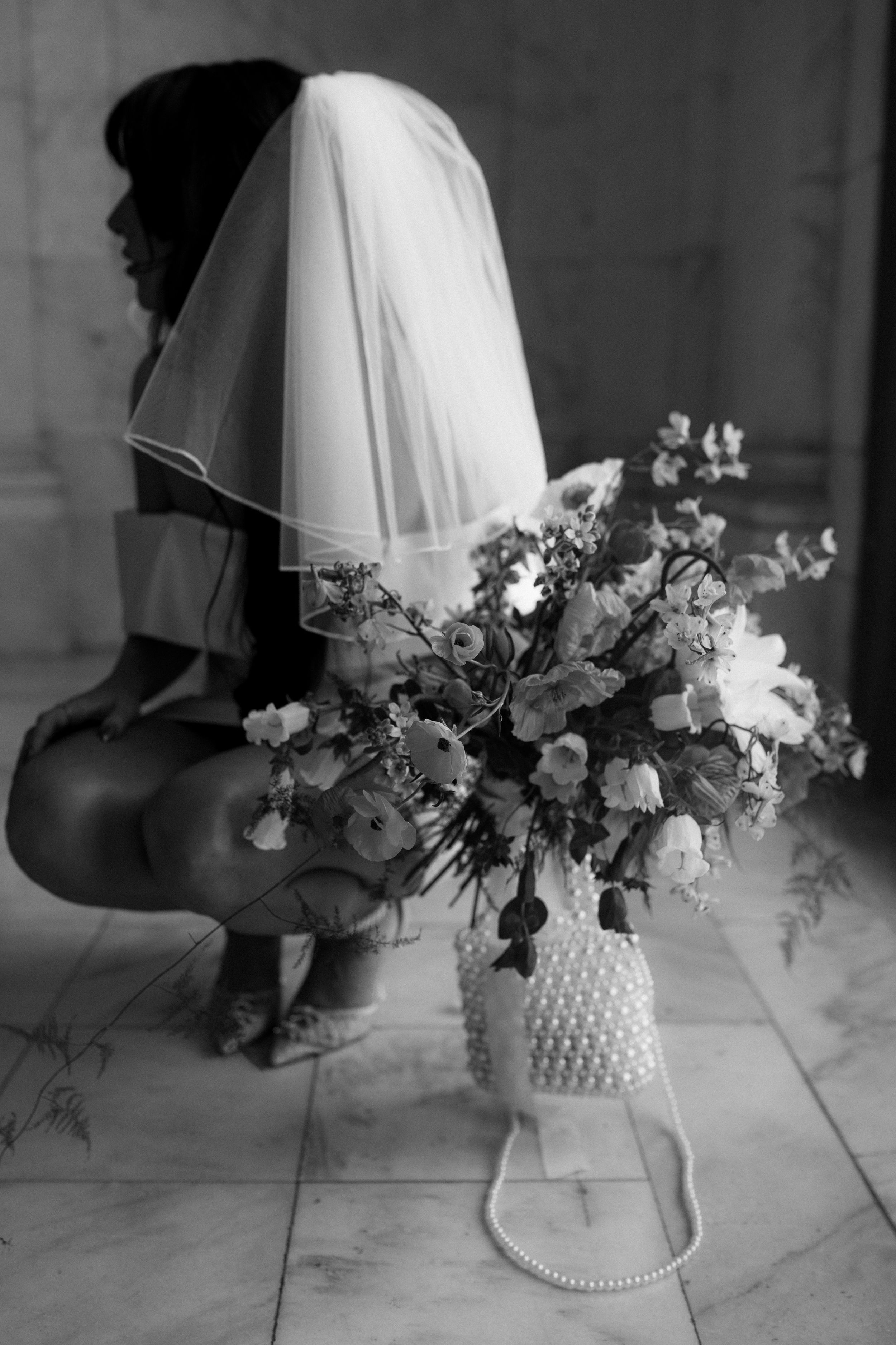 Black and white still life of elegant floral arrangement in white vase.