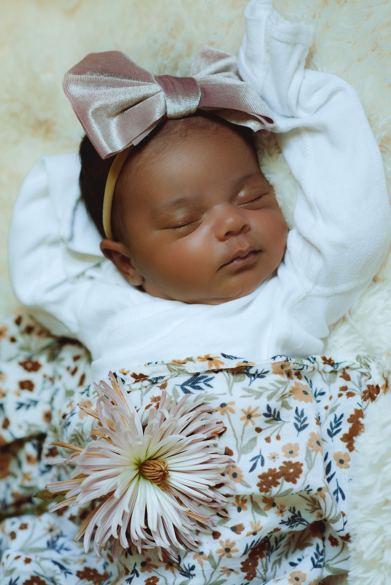 newborn sleeping at in home newborn session in worcester massachusetts posed with flowers