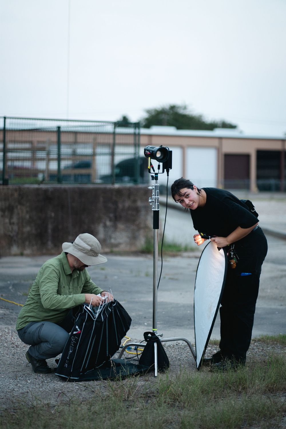 Two crew members setting up camera equipment outdoors.