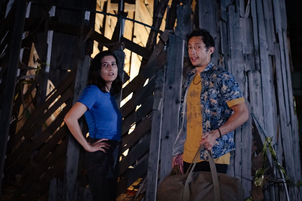 Actors pose in character against a weathered wooden backdrop during filming.