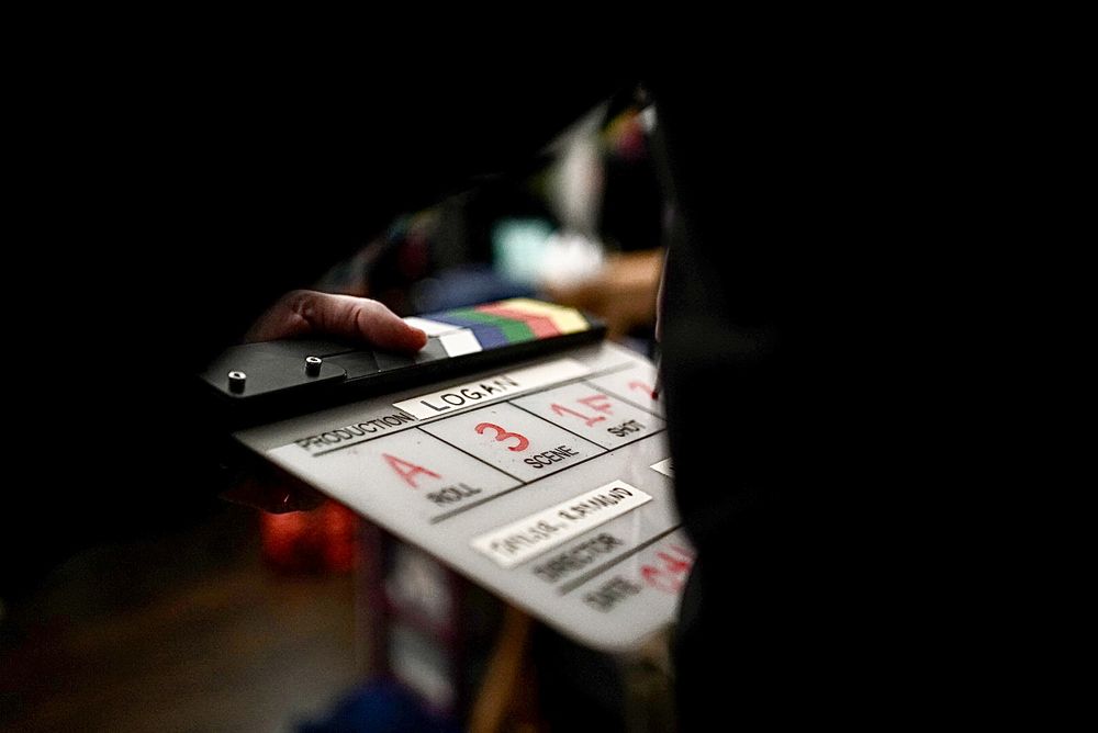 Close-up shot of a film slate in dramatic lighting against a dark background.