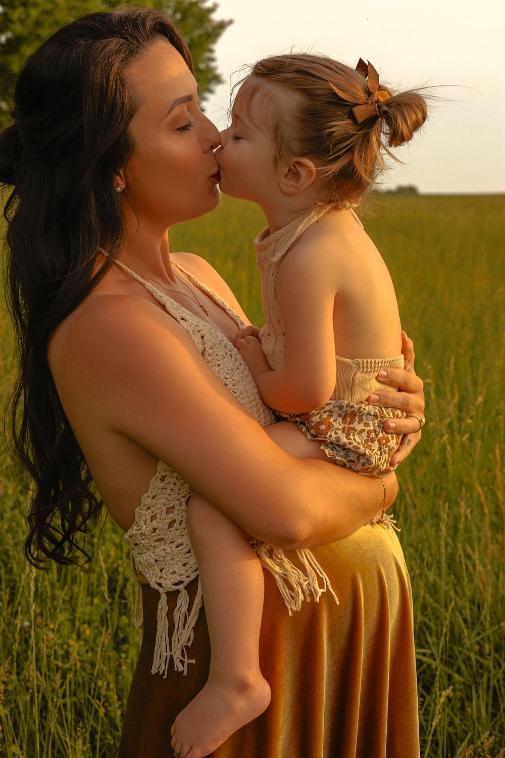 A tender moment between parent and child in a sunlit meadow.