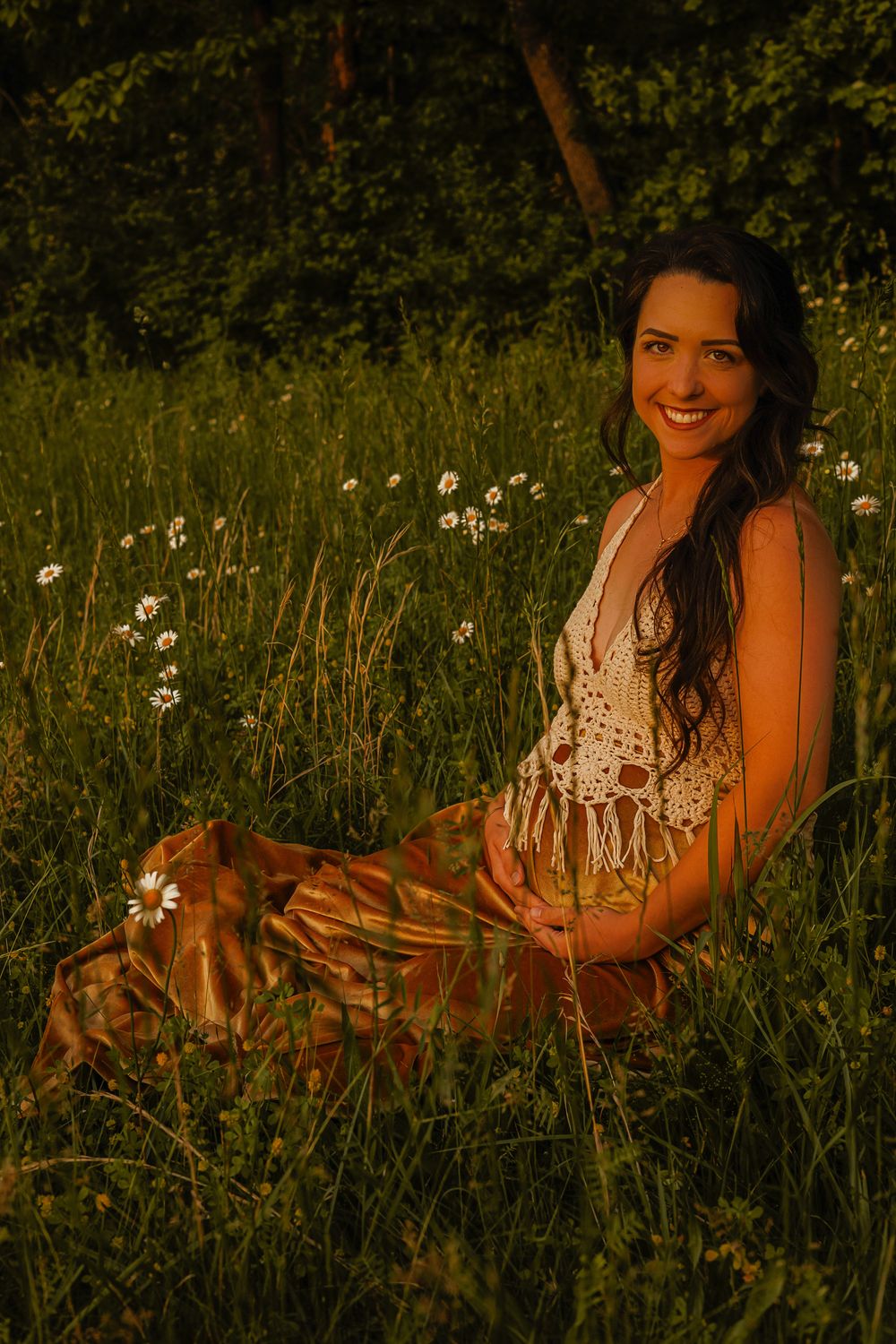 A maternity portrait in a wildflower field at golden hour.