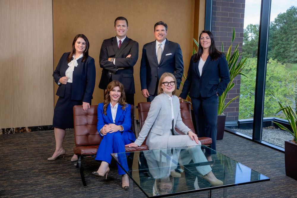 Attorney's branding team photo with professionals arranged casually in an office setting.