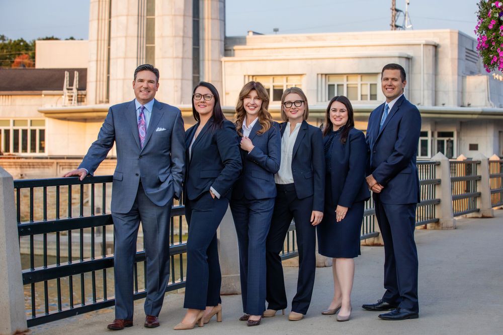 Group of professionals in business attire standing together on a rooftop terrace.