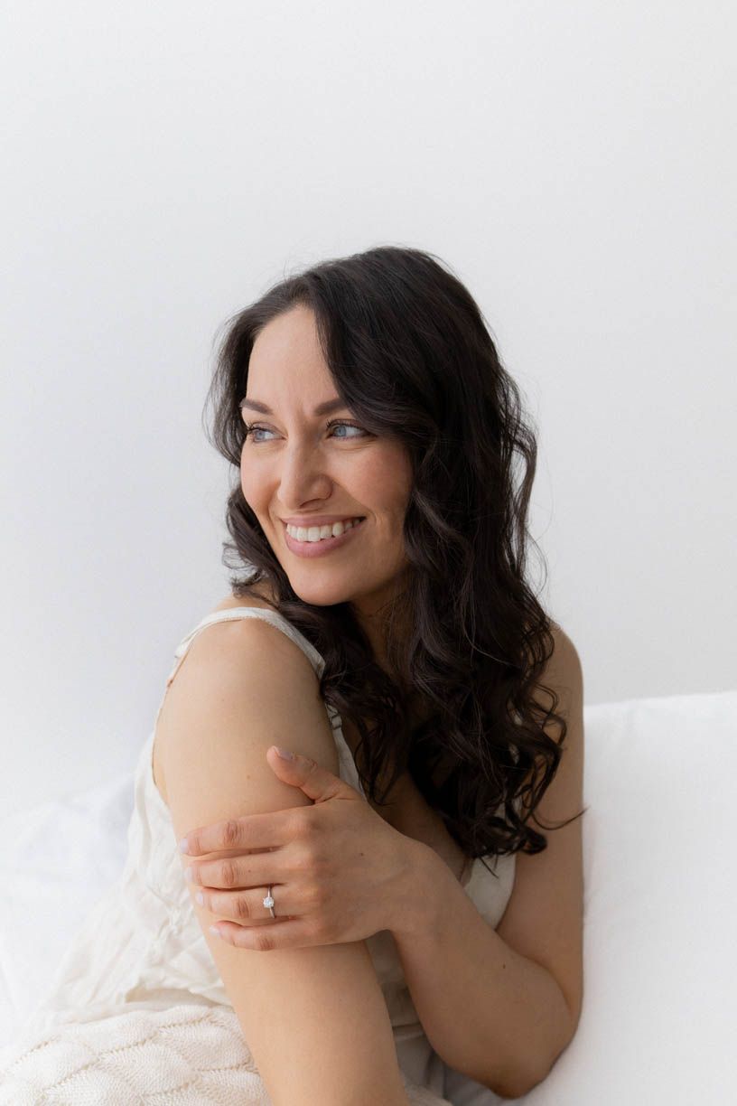 Artistic boudoir photo series showing woman in white fabric posing against light background.