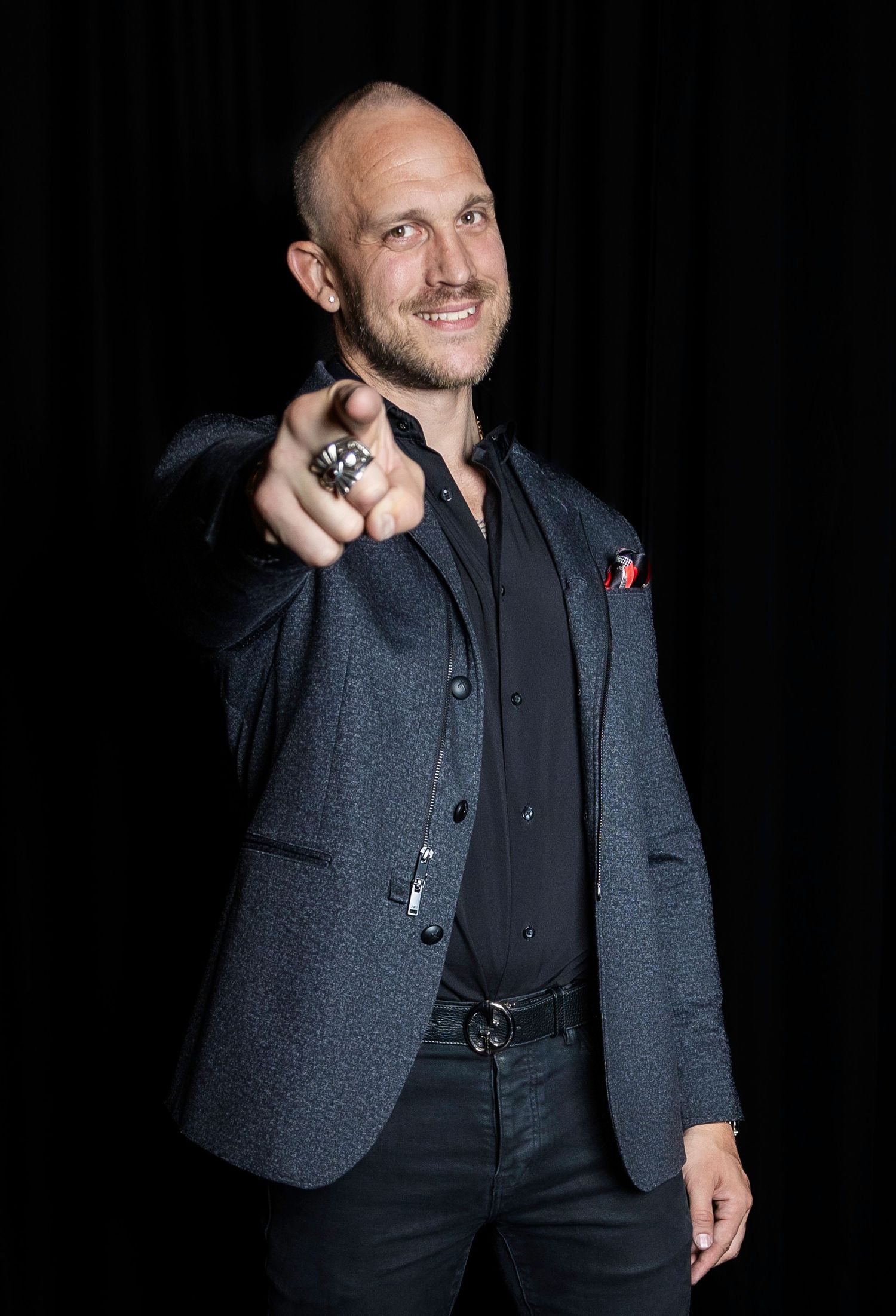 Professional portrait series showing dark blazer and shirt against black background. Headshot