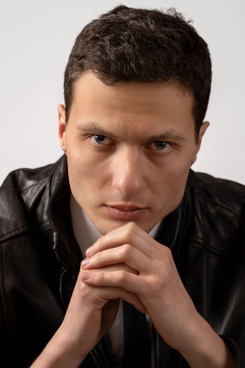 Close-up portraits showing thoughtful expressions against neutral background.