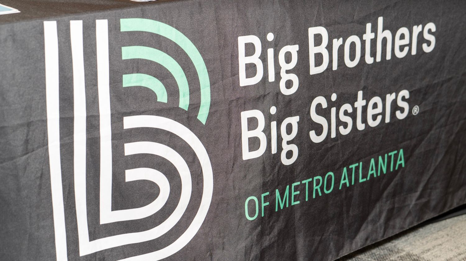 Logo for Big Brothers Big Sisters of Metro Atlanta organization shown on a dark background.