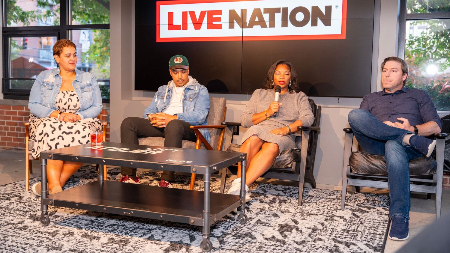 Four people seated on couch during Live Nation office discussion.