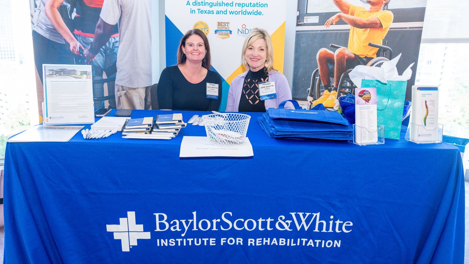 Healthcare staff managing information booth with Baylor Scott & White branded table display.