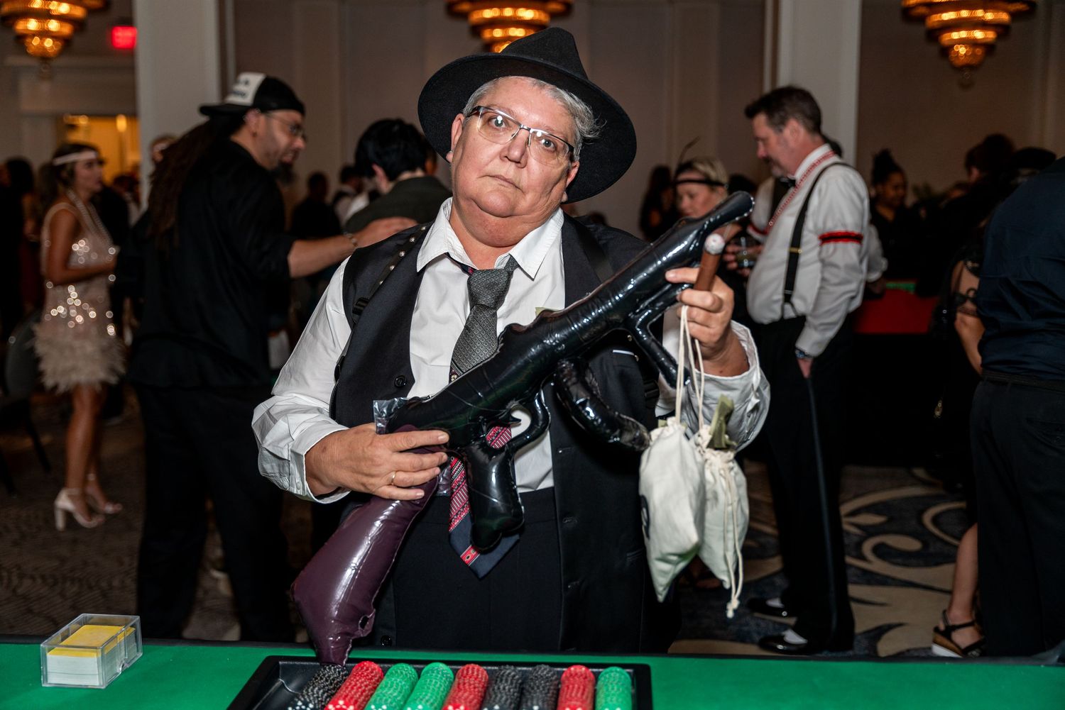 People seated at gaming tables in a dimly lit casino-style environment during an event.
