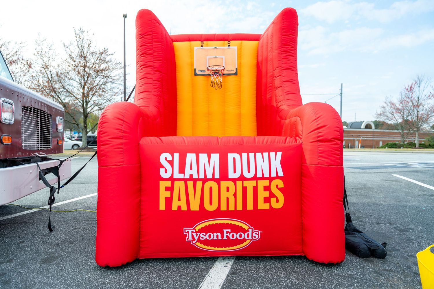 Large red inflatable basketball game attraction with 'Slam Dunk Favorites' branding set up outdoors.