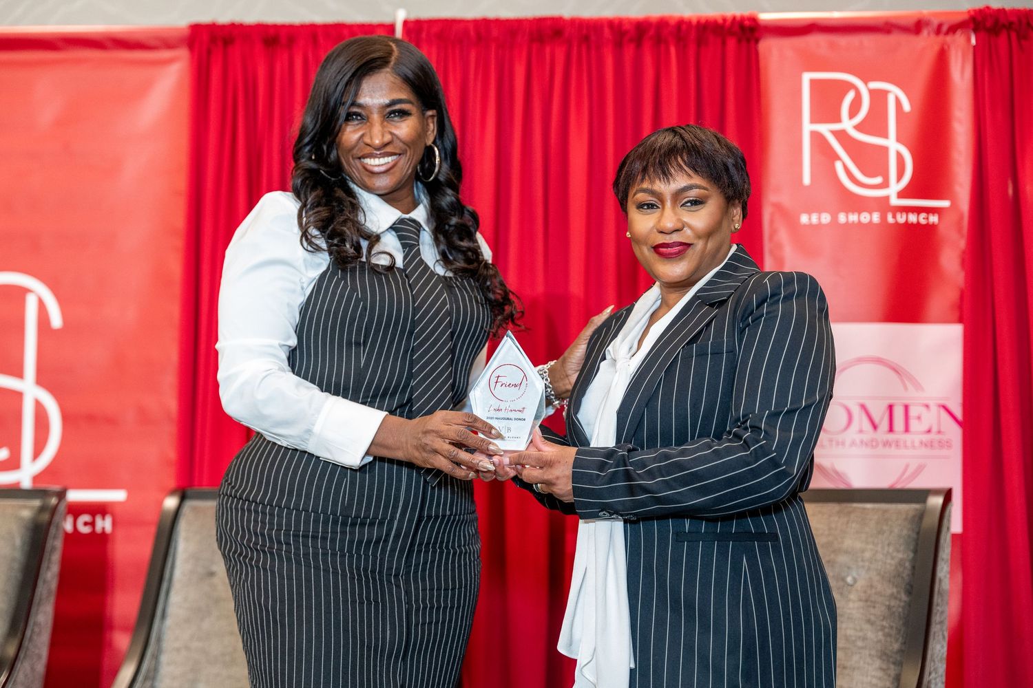 Professional event photos with red backdrop showing people posing together at a business gathering.