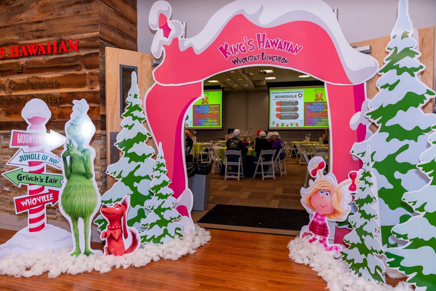 Pink archway entrance to a holiday-themed restaurant with snowy Christmas trees and candy cane decorations.