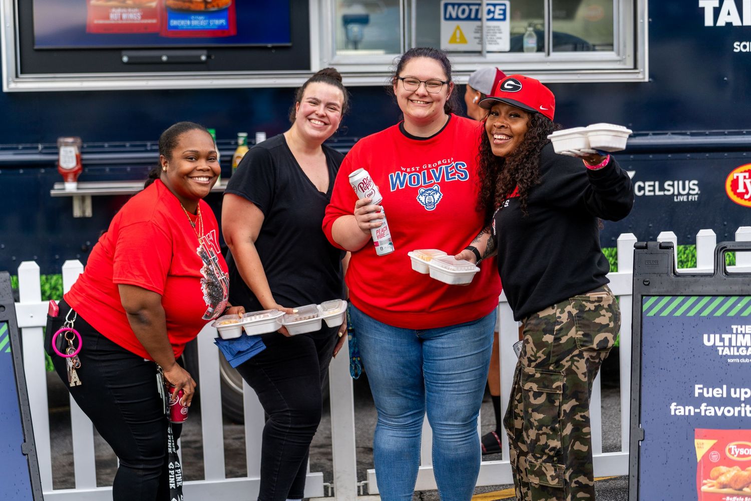 A group of people in red shirts gather outside a convenience store entrance.
