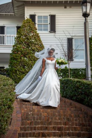 Bride walking down the aisle outdoors with dramatic veil