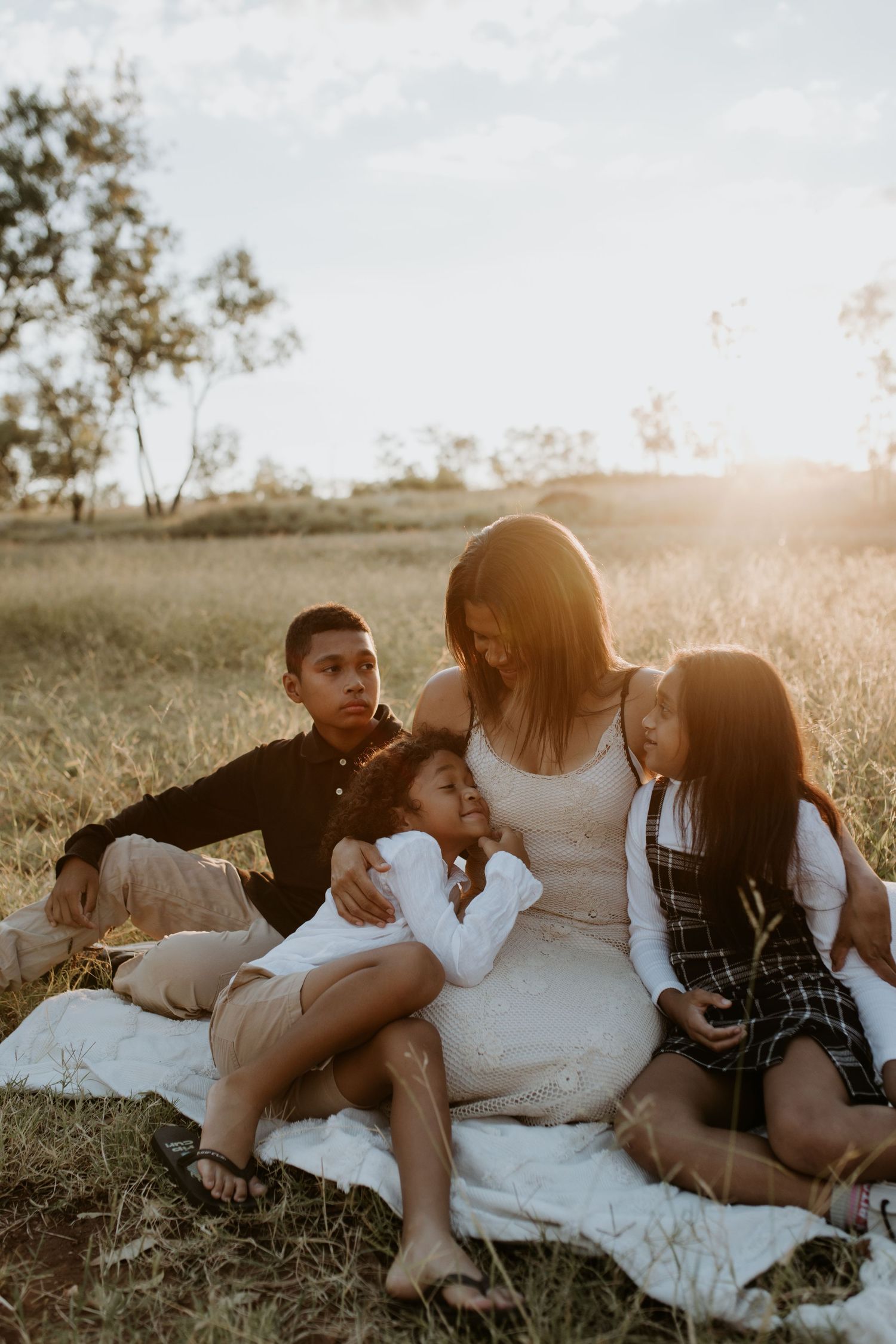 Mother with her kids as sunsets in background in Mount Isa