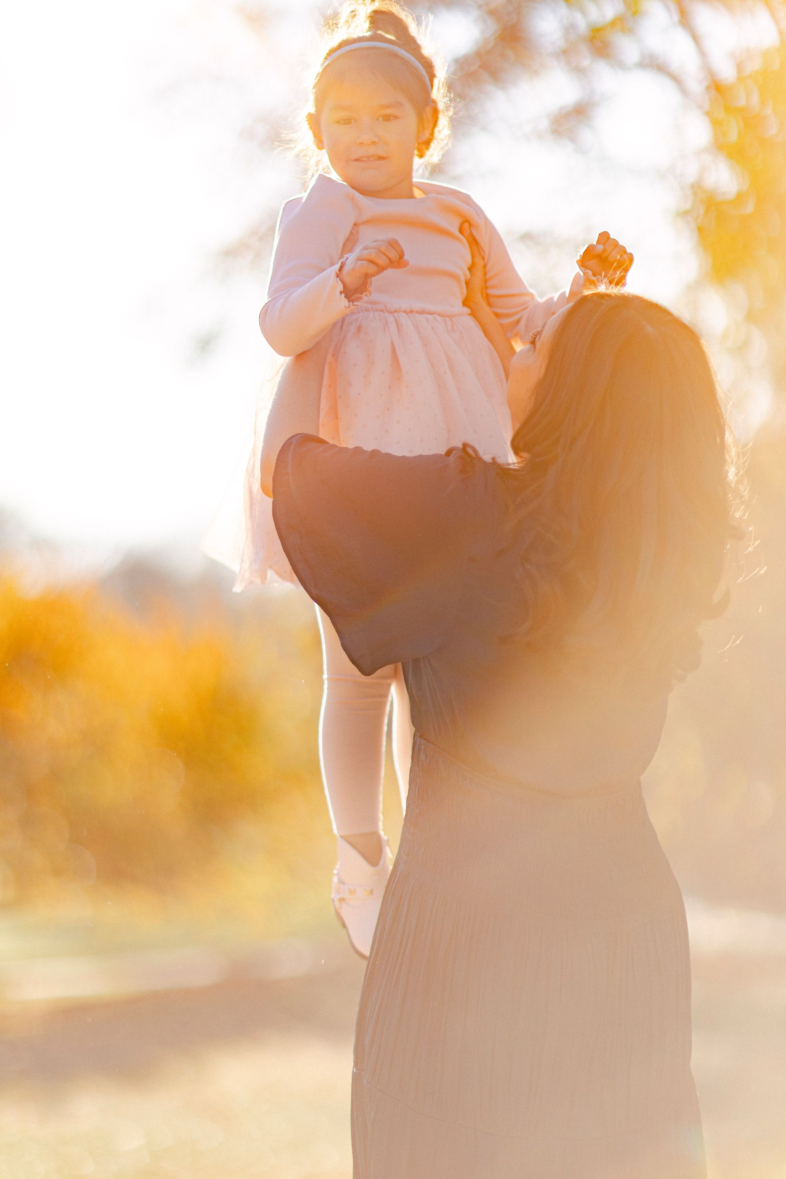 A backlit silhouette of two figures sharing a special moment in golden sunset light.