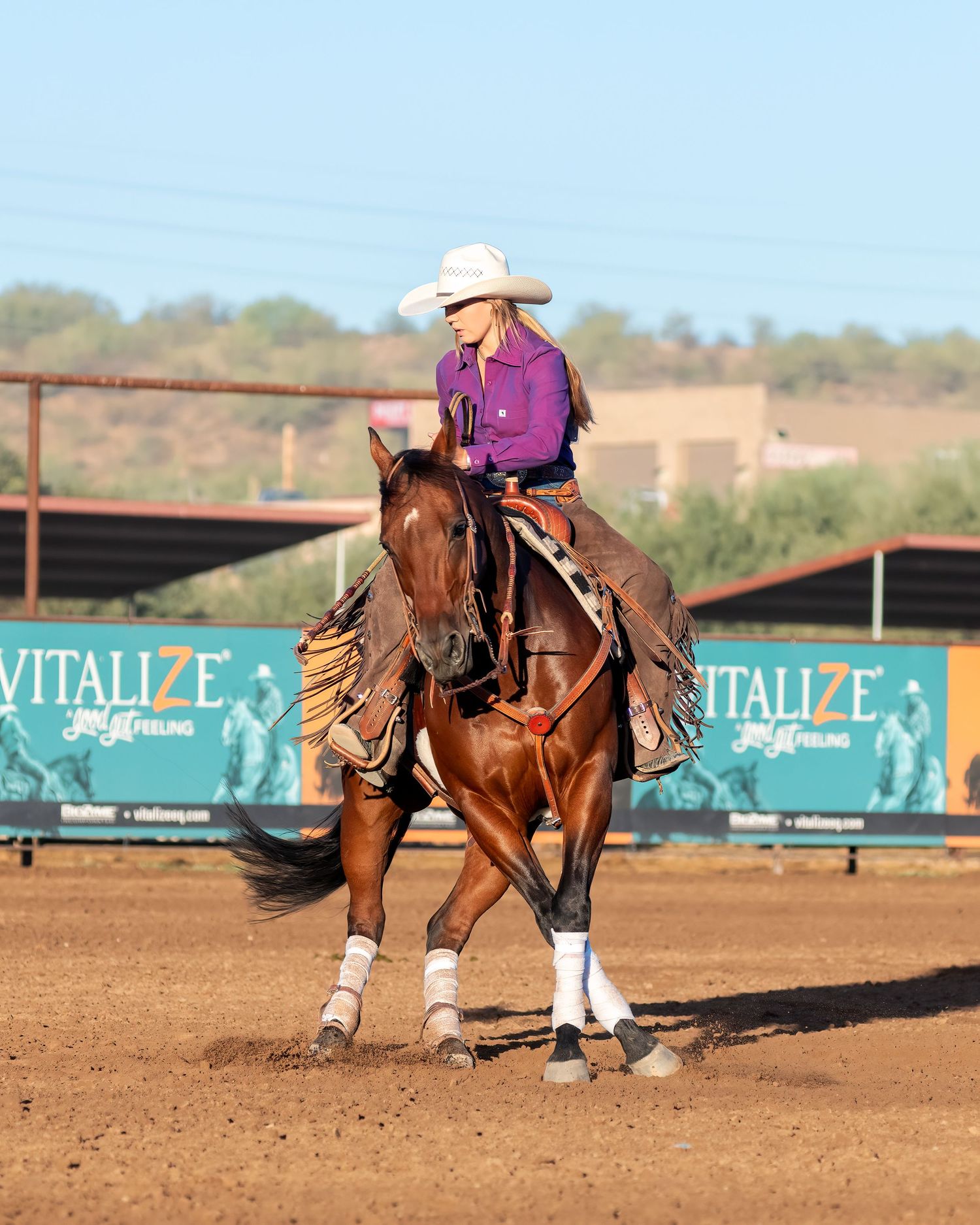 Western riders completes sinning maneuver in a dusty arena.