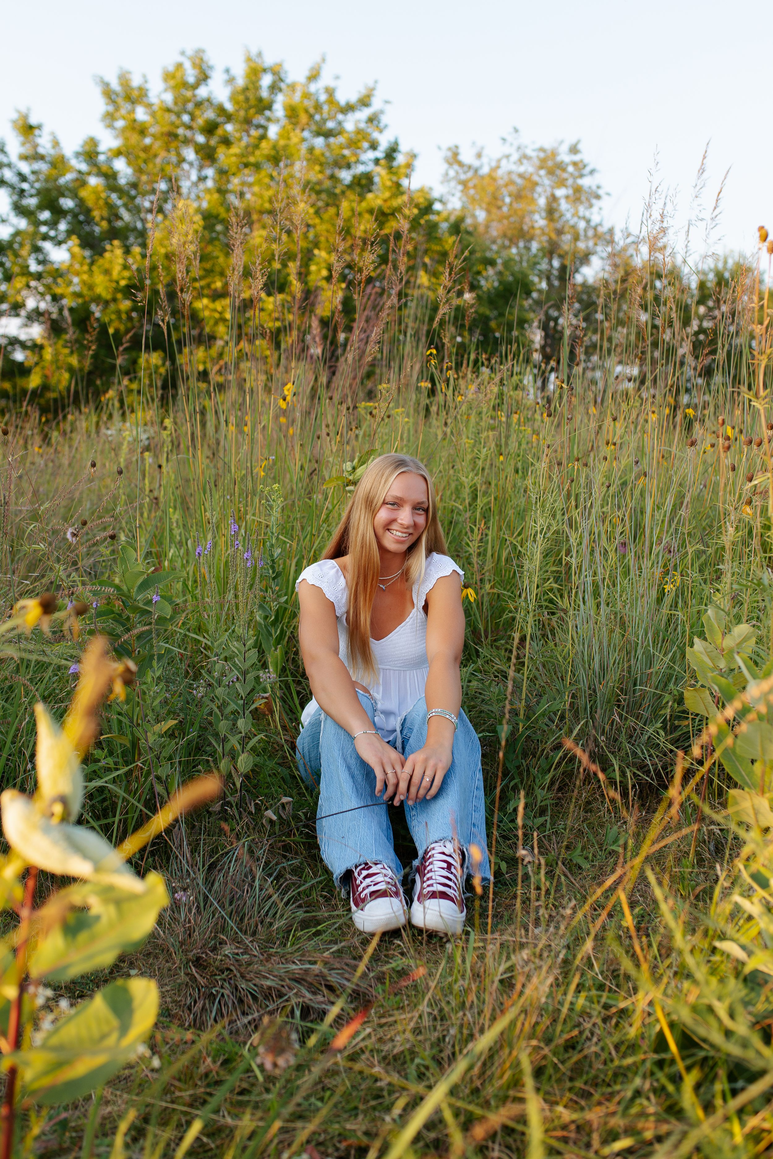 Natural outdoor portrait session in tall grass field during golden hour. Senior photo session. Lake Geneva Wisconsin Photographer