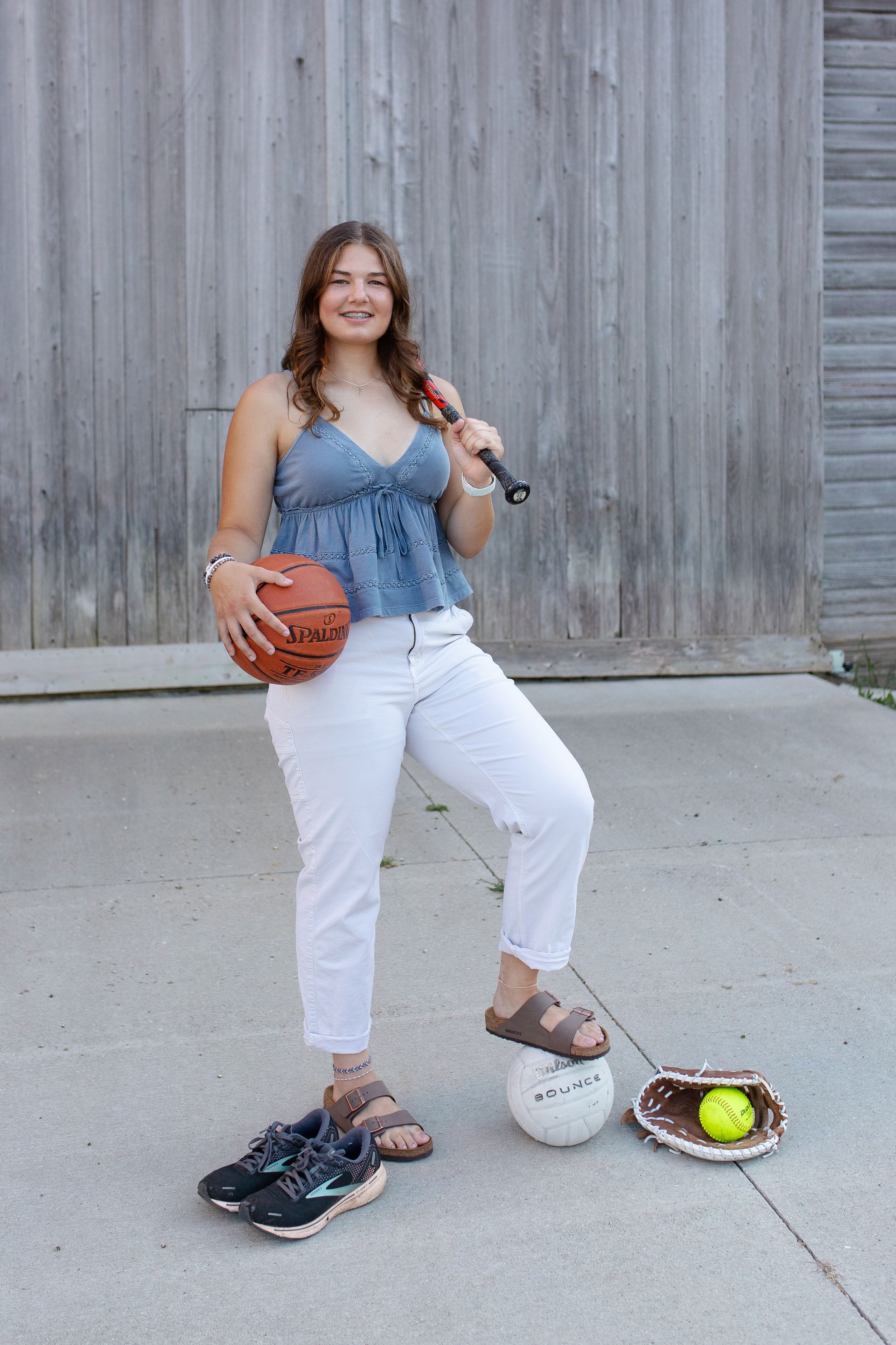 Athletic poses with softball and baseball gear against wooden wall. Senior photo session. Lake Geneva Wisconsin Photographer