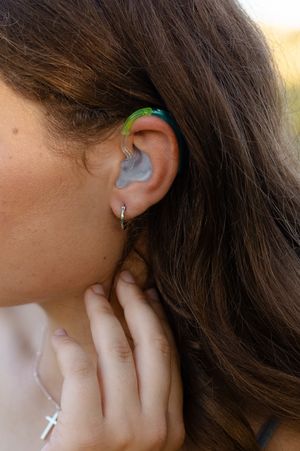 Close-up of silver ear piercings, ocular implant, and jewelry details. Senior photo session. Lake Geneva Wisconsin Photographer