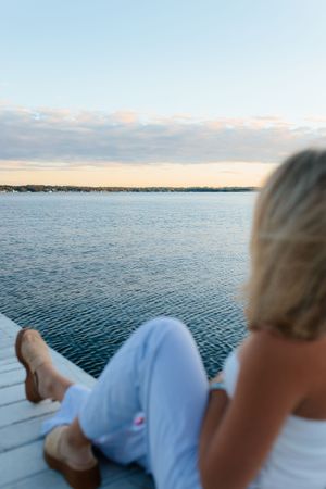 Relaxing waterfront scene with dock overlooking calm waters at sunset. Senior photo session. Lake Geneva Wisconsin Photographer