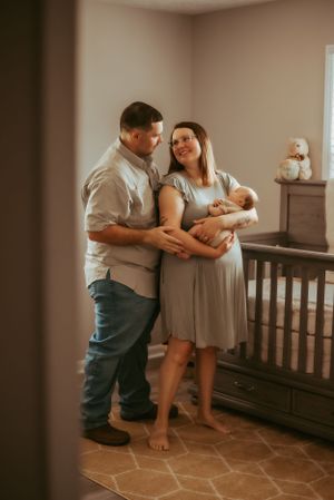 New parents share tender moments with their newborn baby in a nursery setting.