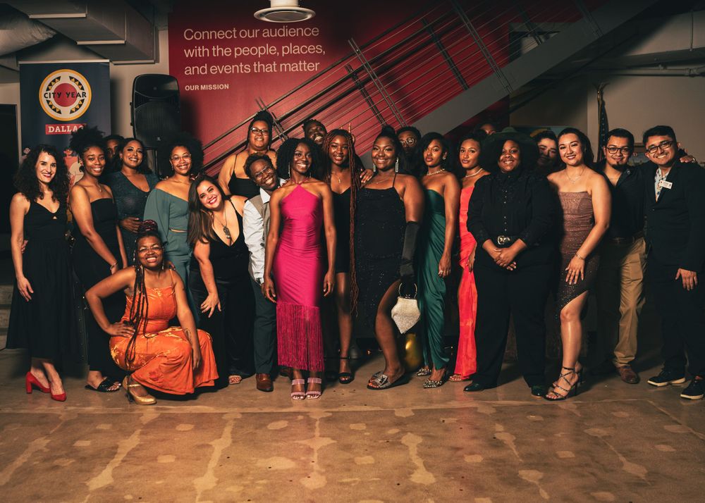 Formal group photo of elegantly dressed people at evening event.