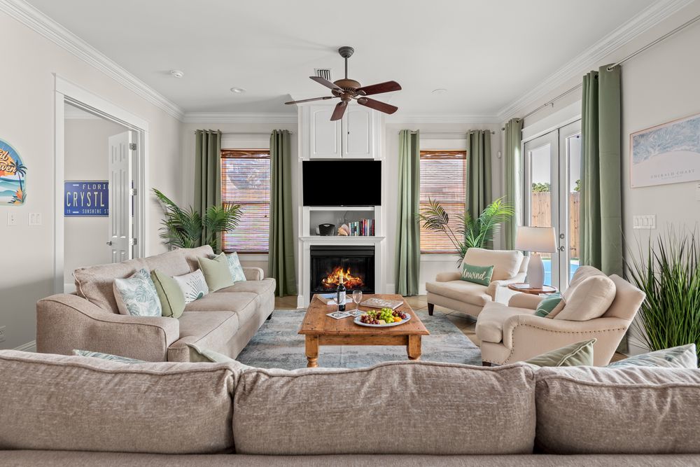Coastal living room design with light gray sofas, fan, and natural accents showcasing a transitional interior style.