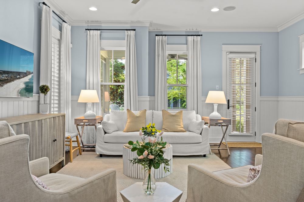 A bright and airy collage of coastal style interior design shots showcasing blue walls and white trim in a modern home.