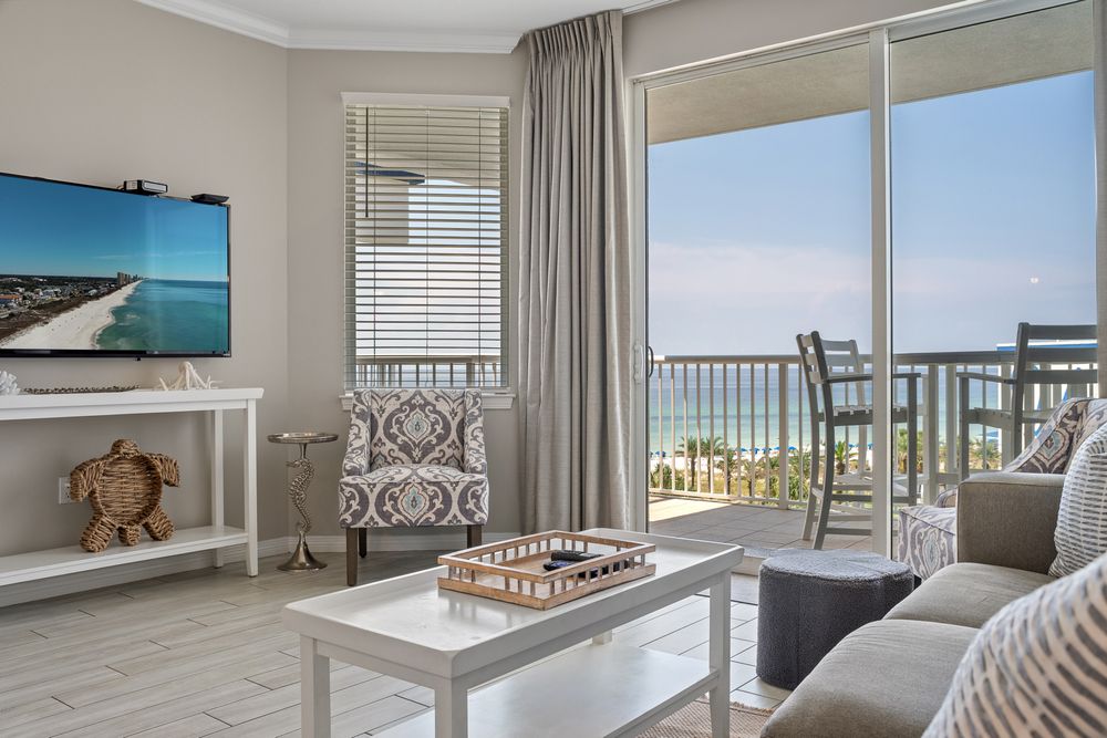 Luxury beachfront condo interior with ocean views showcasing multiple rooms and modern coastal design elements.