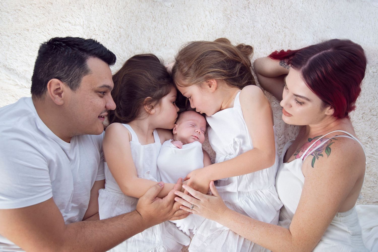 family of 5 lying together for a family portrait in their newborn photography session in pacific pines on the Gold Coast